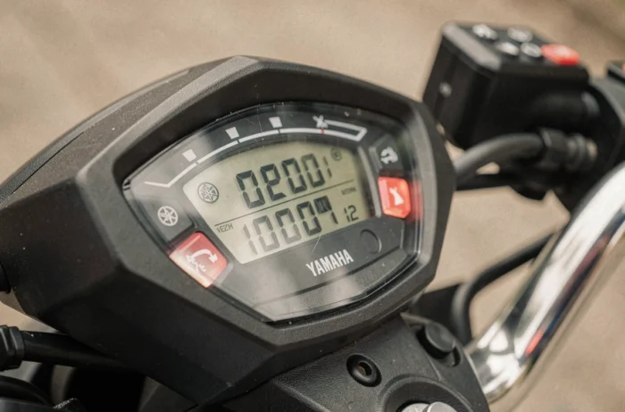 Compteur kilométrique du Yamaha Xmax 125 affichant 10 000 km, gros plan sur le tableau de bord avec clé de contact